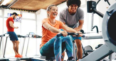 Young beautiful woman doing exercises with personal trainer