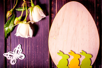 colorful easter rabbits and egg with white rose flowers close-up