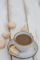 a cup of coffee with pink macaroons