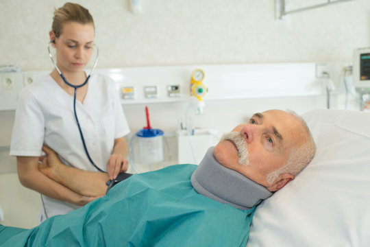 doctor examining senior patient on bed