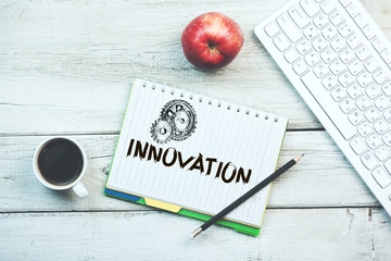 innovation text on notepad with keyboard on table
