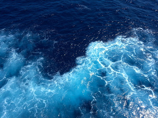 Fototapeta na wymiar ocean-view seascape landscape with blue sky and sunlight big curly ocean wave splitted by waterline to underwater part with air bubbles