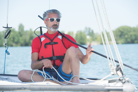 man sailing with sails out on a sunny day