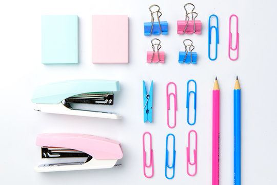 Stationary concept, Flat Lay top view Photo of Scissors, pencils, paper clips, sticky note,stapler in pink and blue tone on white background with copy space