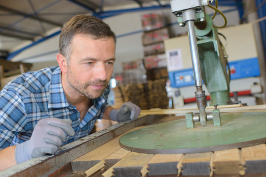 Cooper watching machine press planks of wood together