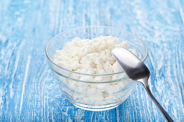 Fototapeta na wymiar cottage cheese in a plate with a spoon