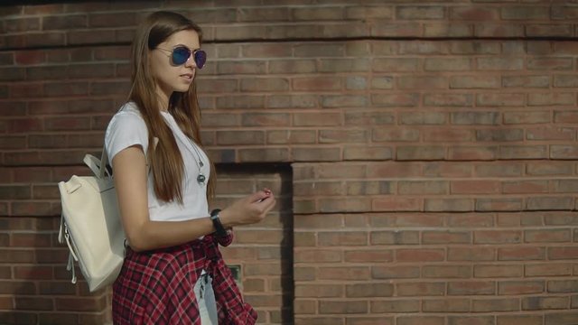 attractive 30s girl with long brown hair and stylish glasses orientiring on the compass to seach right way