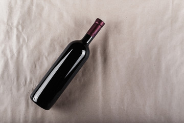 a bottle of red wine on a gray background with space for text. top view