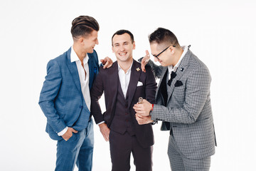 Group of handsome elegant young men in suits talking and laughing. Stag-party concept