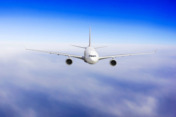 Aircraft is flying in blue cloudy sky. Airplane in the sky