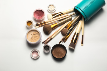 Set of cosmetic brushes, bronzer, eyeshadow in a case on a white background