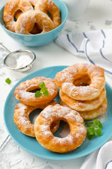 Homemade fried vanilla cottage cheese donuts on a white concrete background