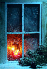 Frosted window with burning candles.Christmas greeting card.Athmosperic photography. Christmas night