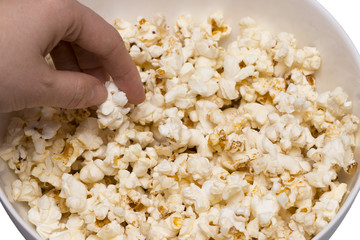 Popcorn viewed from above on blue background. Woman eating popcorn. Human hand. Top view