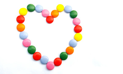 Heart from colorful chocolate candies  on white background
