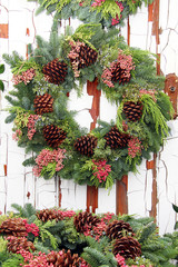 Evergreen Christmas wreath with pine cones on an old weathered wooden door. 