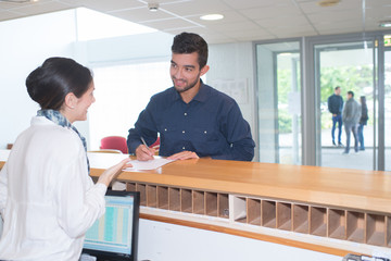 man checking in at reception desk