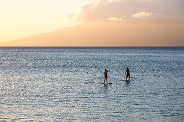 Silhouette of two standup paddlers on Maui, Hawaii