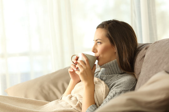 Woman relaxing at home drinking coffee