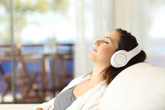Woman relaxing listening to music on a couch