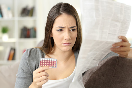 Worried woman reading contraceptive pills leaflet