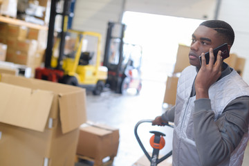 Warehouse worker using mobile phone