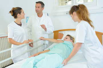 Obraz na płótnie Canvas nurse rolling patient over in hospital bed