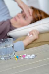 Obraz na płótnie Canvas depressed female iwith pills on the table