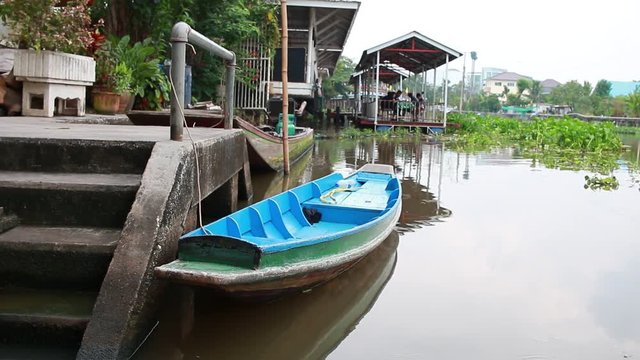 Long tail boat on the river with quiet atmosphere on the bank of the river in Thailand.