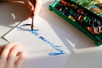 Female calligrapher creates inscription for sale, using brushes 