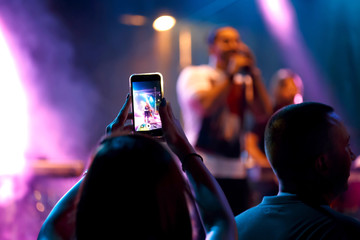 People taking photo with phone on concert