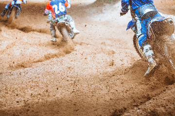 Details of flying debris during an acceleration with mountain bikes race in dirt track in sunshine...