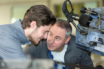 professional teacher showing machinery to student