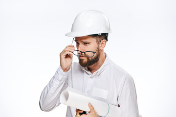 Engineer with a beard on a white isolated background holds a blueprint, builder