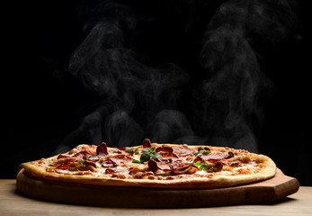 Hot big pepperoni pizza tasty pizza composition with melting cheese bacon tomatoes ham paprika steam smoke - 181417453