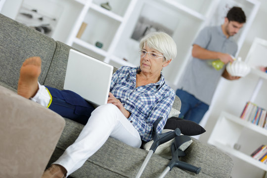 mature woman with injured leg relaxing on the sofa