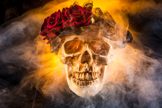 The skull of a man in the smoke. Skull with a wreath of flowers.