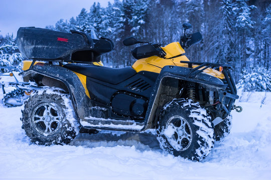 Quad bike in the snow. AVT is a yellow color.