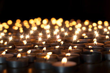 Tealight candles. Beautiful Christmas celebration, religious or remembrance candlelight image. Romantic candlelit vigil - obrazy, fototapety, plakaty