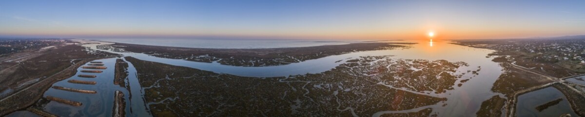 Aerial sunset seascape in Ria Formosa wetlands natural park, inland maritime channel. Algarve.