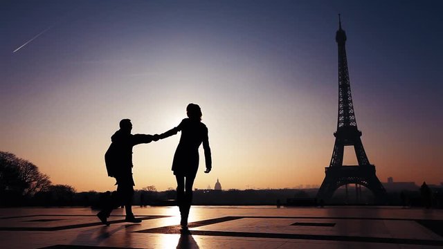 happy couple on honeymoon in Paris, silhouettes of man and woman near Eiffel tower