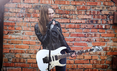 Fototapeta na wymiar Beautiful young girl rocker with electric guitar. A rock musicia