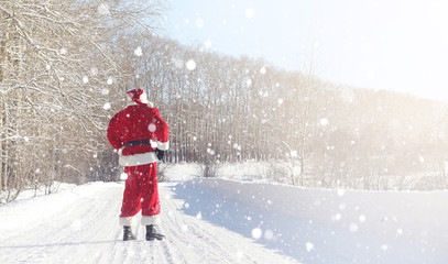 Santa Claus comes with gifts from the outdoor. Santa in a red su