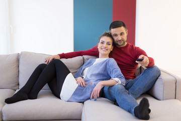 Fototapeta na wymiar Young couple on the sofa watching television