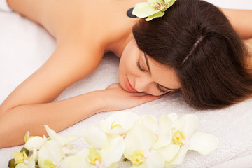 Obraz na płótnie Canvas Spa Stone Massage. Beautiful Woman Getting Spa Hot Stones Massage in Spa Salon. Beauty Treatments Outdoor. Nature
