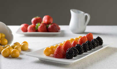 strawberries, golden berry and black berry with on a plate as a sweet snack.