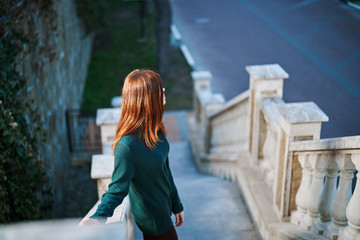 A woman walks down a beautiful staircase, a street