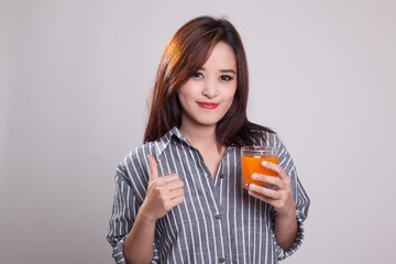 Young Asian woman thumbs up drink orange juice.