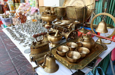 Brass cup, hot pot and souvenir on a desk for sell at Yaowarat market, Bangkok, Thailand