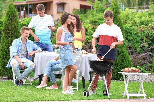 Young friends having barbecue party in garden